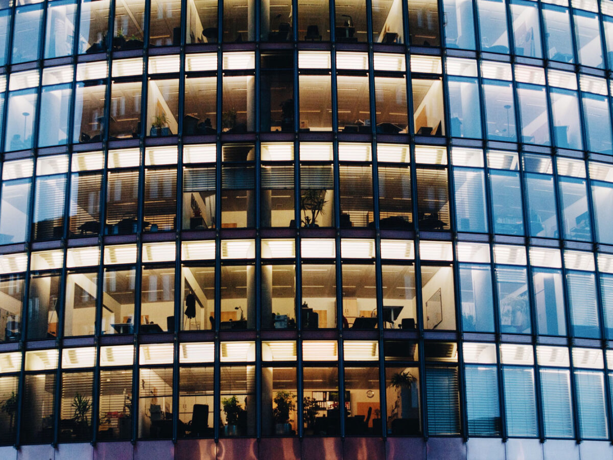 Tall skyscraper building with offices lights on in the middle.